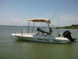 man sitting on his fishing boat under the Bimini top