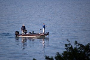 two fishermen on a boat enjoying the lake on a nice day