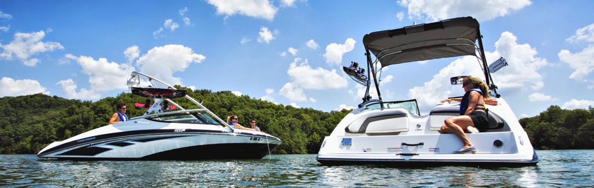 people hanging out on two boats in the water on a sunny day