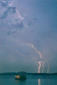 boat on the water with lightning in the sky