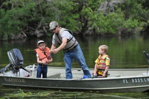 2 children and father in boat learning to fish