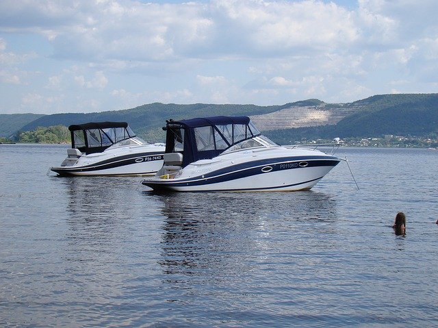 moored boats in foreground with beautiful mountain views in background